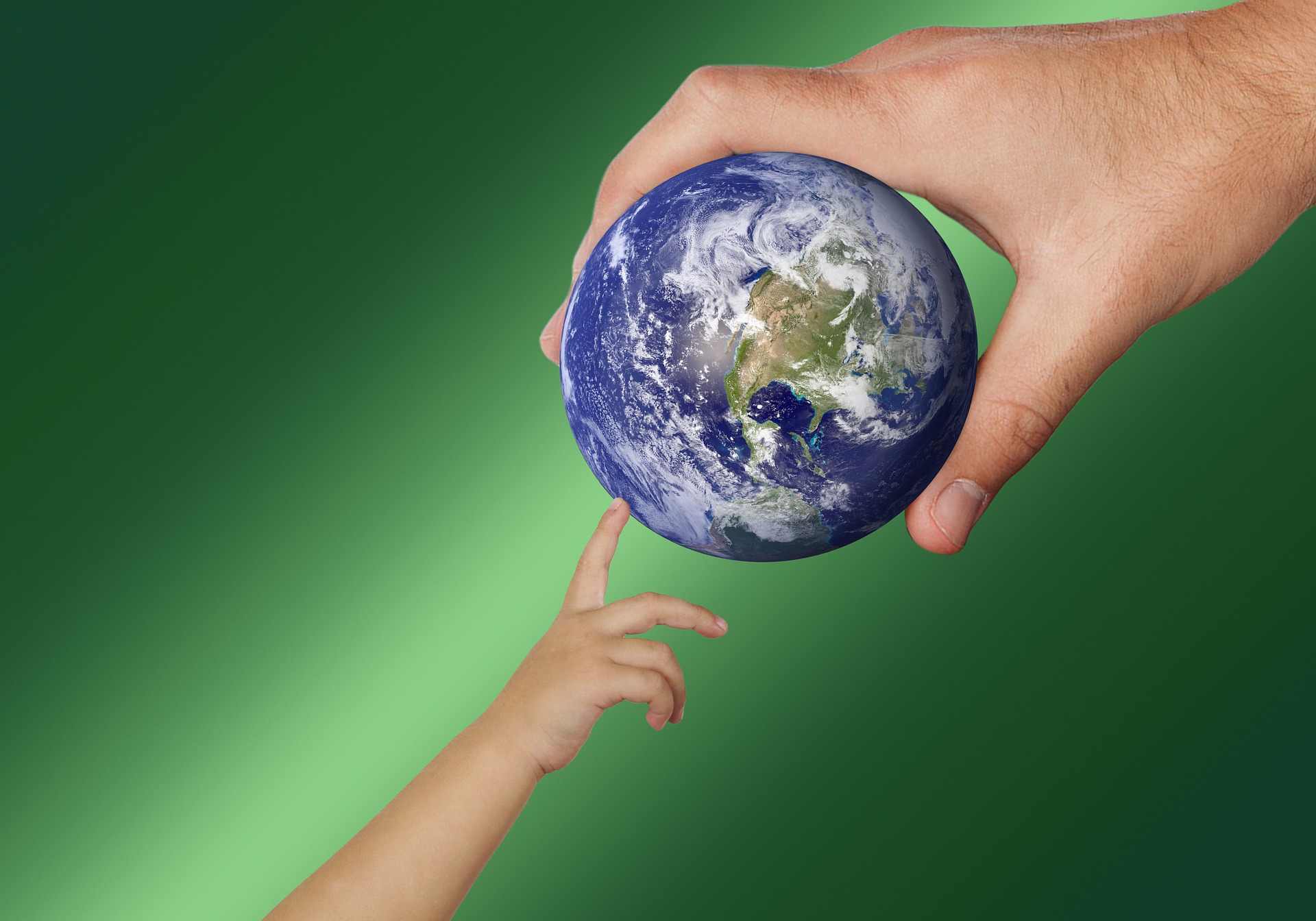 A picture.  A man's hand at top right holds a small planet earth.  Reaching up from bottom left, a child's hand stretches out to touch it