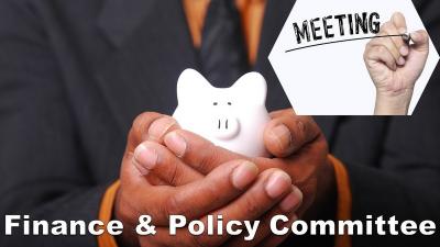 An image shows a man's chest with hands cupped in front of him holding a ceramic pig. He wears a suit and tie. Text reads Meeting: finance and policy committee