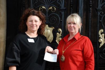a-cheque-for-revitalise: a photo of two women, head and shoulders. They face the camera and hold a piece of paper between them