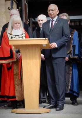 people in formal attire stand around a lectern