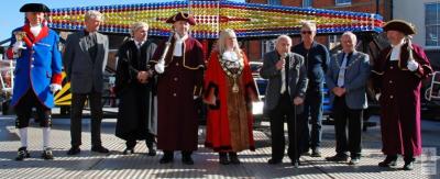 a group of people in ceremonial dress stand on the steps of a fairground ride
