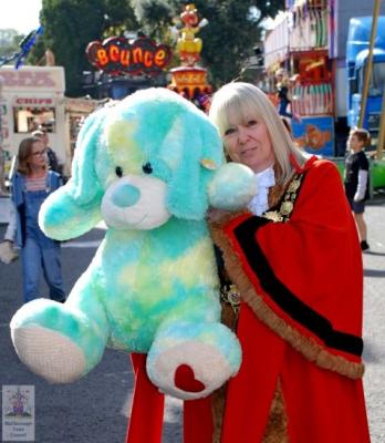 a woman wearing ceremonial robes and holding a very large cuddly toy